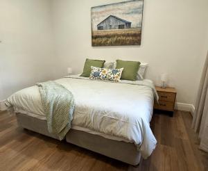 a bedroom with a bed and a painting on the wall at Perrys Place in Nuriootpa