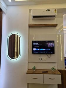 a room with a flat screen tv on the wall at The Happy Nook Stays in Winsten Park Knowledge Park V in Noida