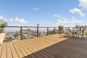 a wooden deck with a table and chairs on it at Stunning Views by the Bay 2BR in Brisbane