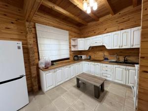 a kitchen with white cabinets and a wooden ceiling at Семейный коттедж in Bulan Sogottuu