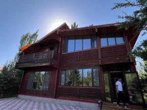 a man standing in the doorway of a house at Семейный коттедж in Bulan Sogottuu