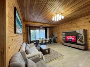 a living room with a couch and a television at Семейный коттедж in Bulan Sogottuu
