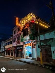 a building with a neon sign on the side of it at HOUSSE 69 Café Bar in Satipo