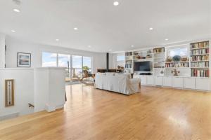 a large living room with white walls and wooden floors at Stunning Views by the Bay 2BR in Brisbane