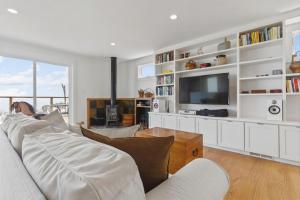 a living room with a white couch and a tv at Stunning Views by the Bay 2BR in Brisbane +40 photos