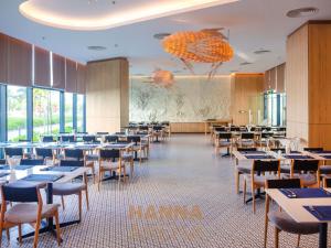 a dining room filled with tables and chairs at Hanna Seaview Stella - The Arena Resort in Cam Ranh International Airport