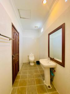a bathroom with a toilet and a sink and a mirror at STC Hotel School in Phumĭ Réach Born (1) +23 photos