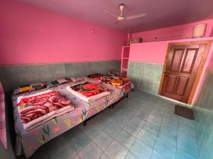 a bedroom with a bed in a room with pink walls at Omji Ashram - Tapovan Kuti in Uttarkāshi