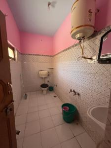 a bathroom with a toilet and a sink at Omji Ashram - Tapovan Kuti in Uttarkāshi