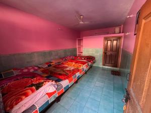 two beds in a room with pink walls at Omji Ashram - Tapovan Kuti in Uttarkāshi +8 photos