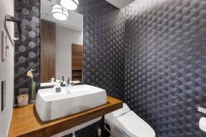 ein Badezimmer mit einem weißen Waschbecken und einem Spiegel in der Unterkunft Miko - Rusutsu Chalets in Rusutsu + 39 Fotos