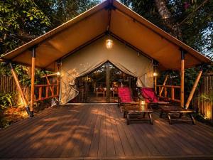 a wooden deck with chairs and a tent at Chateau Orientale Resort in Luang Prabang