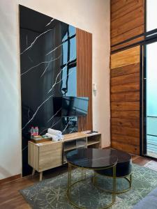 a living room with a table and a tv at Villa Dieng Sikapuk Hill Superior Cabin in Kejajar