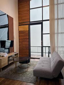 a living room with a couch and a large window at Villa Dieng Sikapuk Hill Superior Cabin in Kejajar +1 photo