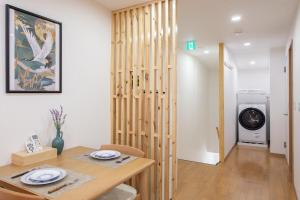 a dining room with a table and a washing machine at Lucky Today in Osaka