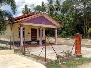 a small house with a fence in front of it at Homestay Adilah A in Pasir Puteh