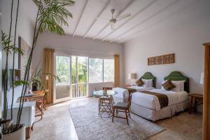 a bedroom with a bed and a couch and a table at Room & Vespa 4 - Central Seminyak Near Beach in Seminyak +49 photos