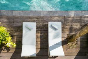 two toothbrushes sitting on a wall next to a pool at Room & Vespa 4 - Central Seminyak Near Beach in Seminyak