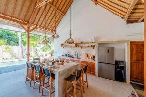 an open kitchen with a large table and chairs at Villa Manouch in Nusa Lembongan