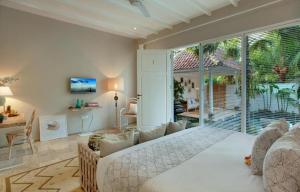 a living room with a bed and a large window at Room & Vespa 4 - Central Seminyak Near Beach in Seminyak