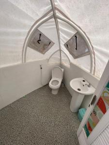 a toy bathroom with a toilet and a sink at Glamping Dieng Sunrise Point Larva Camp in Kejajar