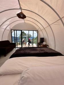 a room with a bed in a tent at Glamping Dieng Sunrise Point Larva Camp in Kejajar