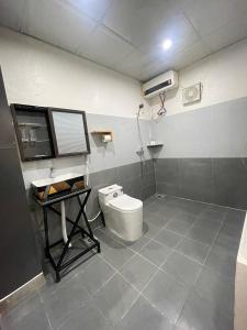a bathroom with a toilet and a desk with a hair dryer at MAI CHAU inn in Mai Châu