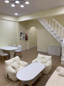 a living room with white furniture and a staircase at Caesar's Corner 2 Bedroom House in Ban Lak Roi