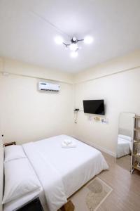 a bedroom with a white bed and a flat screen tv at Caesar's Corner 2 Bedroom House in Ban Lak Roi +20 photos