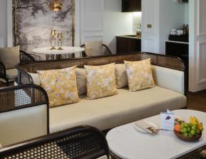 a couch with pillows sitting in a room with tables at CHINO@NIMMAN Luxury Boutique Hotel in Chiang Mai