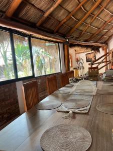 a room with a long table with chairs and windows at Condominio La Palapa in Bucerías