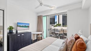 a bedroom with a king sized bed and a balcony at Mantra Hotel Room in Cairns