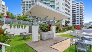 a pavilion with tables and chairs in a garden at Mantra Hotel Room in Cairns