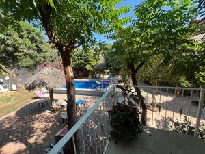 a fence next to a swimming pool with a tree at Condominio La Palapa in Bucerías
