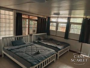 two twin beds in a room with windows at Casa Scarlet in Bangkok