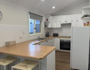 a kitchen with white cabinets and a wooden counter top at Perrys Place in Nuriootpa