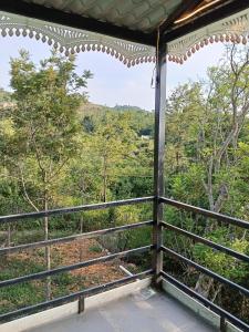 a room with a view of a forest from a balcony at Pani thuzhi in Salem