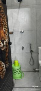 a bathroom with a shower with a leopard on the wall at Dreamers Lounge in Trichūr +7 photos