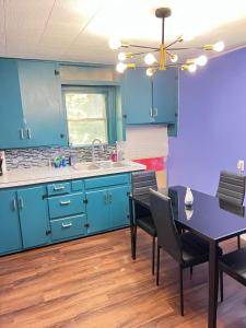 a kitchen with blue cabinets and a table and chairs at Pet friendly Newly renovated Two bedroom Property in Central Okc in Oklahoma City +25 photos