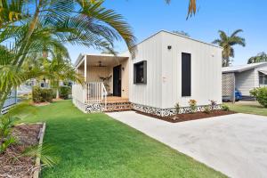 a white house with a palm tree in a yard at Ingenia Holidays Hervey Bay in Hervey Bay