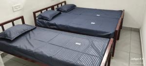 two twin beds in a room with blue sheets at Dreamers Lounge in Trichūr