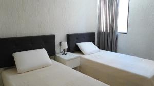 ein Zimmer mit zwei Betten und einem Fenster in der Unterkunft Casa Torremolinos en Coto Privado in Zapopan