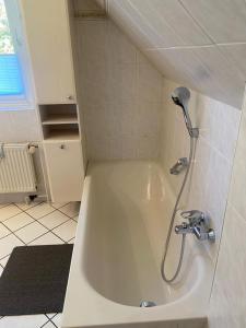 a white bath tub with a shower in a bathroom at Nordstern 3 in Dahme +18 photos