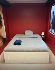 a bed in a red room with two blue towels on it at Funky artists studio in Paris in Pantin