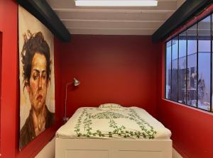 a red room with a painting of a man at Funky artists studio in Paris in Pantin