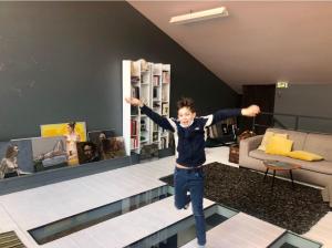 a young boy jumping on a pool in a living room at Funky artists studio in Paris in Pantin