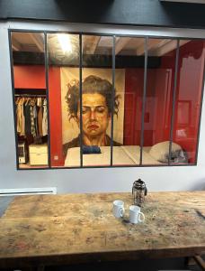 a painting of a man with two cups on a table at Funky artists studio in Paris in Pantin +3 photos