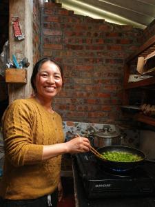 a woman stirring a bowl of greens in a pan at PhinFamilyHomestay in Tả Van +8 photos