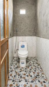 a bathroom with a toilet with a tiled floor at PhinFamilyHomestay in Tả Van