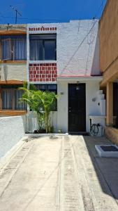 ein Gebäude mit einer Tür und einer Palme davor in der Unterkunft Casa Torremolinos en Coto Privado in Zapopan